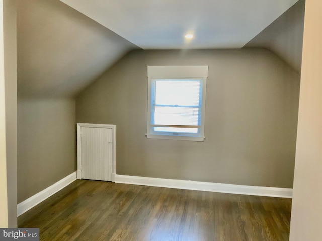 additional living space featuring lofted ceiling, baseboards, and wood finished floors