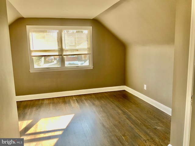 bonus room featuring dark wood-style floors, lofted ceiling, and baseboards