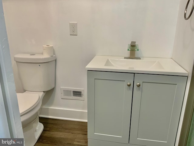 bathroom featuring vanity, toilet, wood finished floors, and visible vents