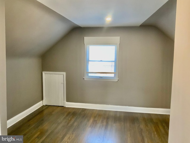 bonus room with baseboards, dark wood-type flooring, and lofted ceiling