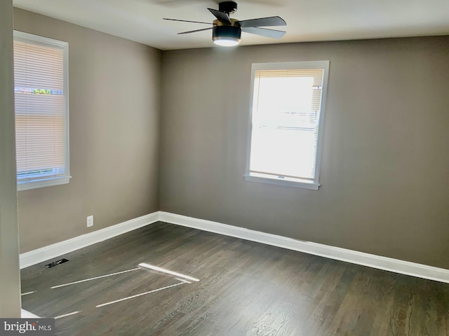 unfurnished room featuring visible vents, baseboards, wood finished floors, and a ceiling fan