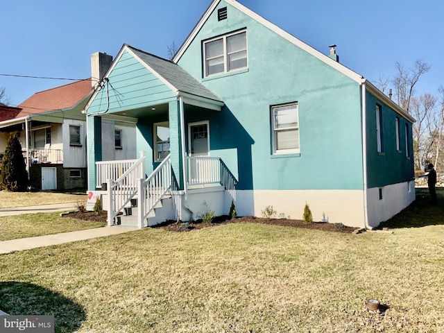 view of front of home with covered porch and a front lawn