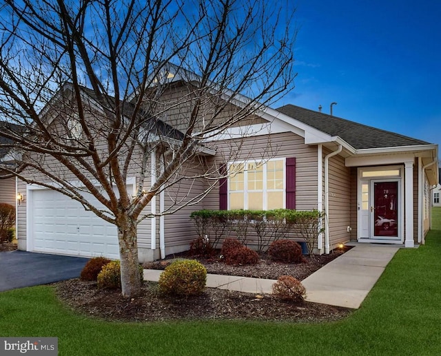 view of front facade with a front lawn, a garage, driveway, and a shingled roof