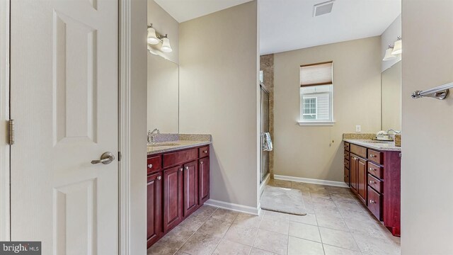 full bathroom featuring visible vents, a shower stall, vanity, and baseboards