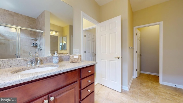 bathroom with vanity, a shower stall, baseboards, and tile patterned flooring