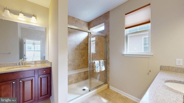 full bath with tile patterned floors, baseboards, a shower stall, and vanity