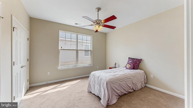 bedroom featuring visible vents, baseboards, light colored carpet, and ceiling fan