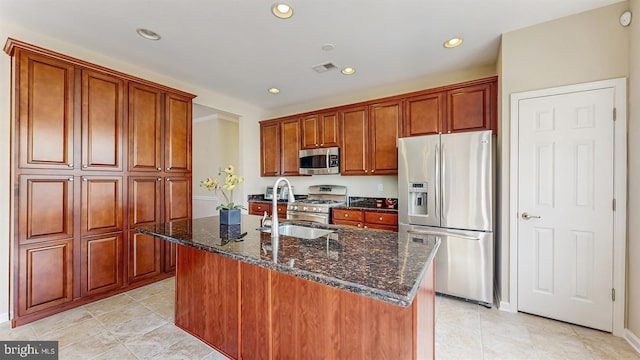 kitchen with dark stone countertops, recessed lighting, appliances with stainless steel finishes, and a sink