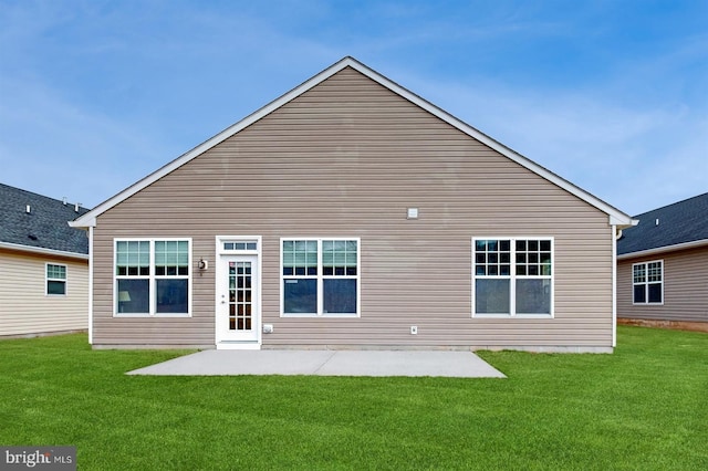 rear view of house with a patio and a yard