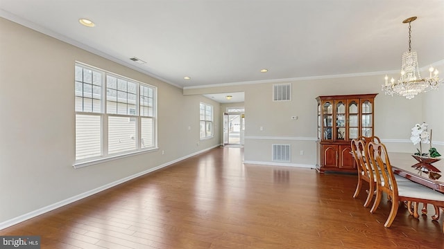 dining space with a notable chandelier, visible vents, and wood finished floors