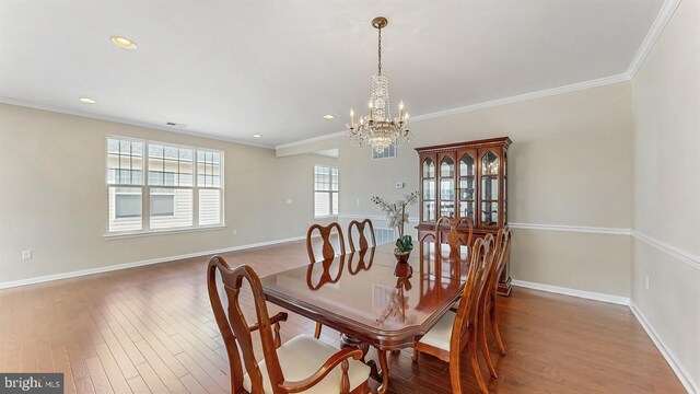 dining room featuring ornamental molding, baseboards, an inviting chandelier, and wood finished floors