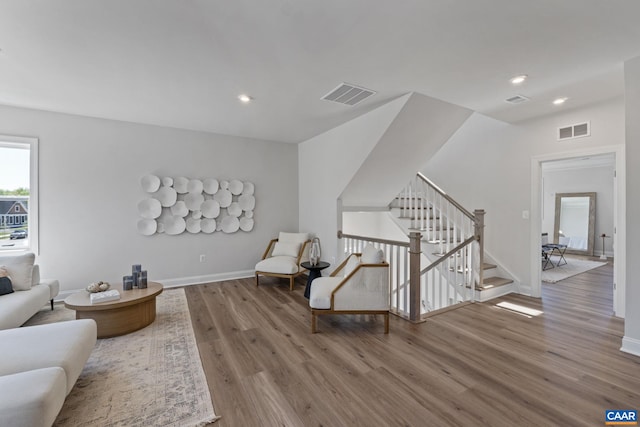 sitting room with recessed lighting, visible vents, wood finished floors, and stairway