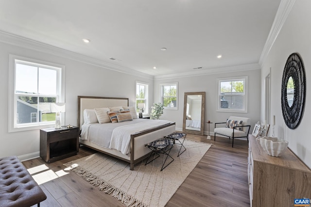 bedroom featuring recessed lighting, wood finished floors, baseboards, and ornamental molding