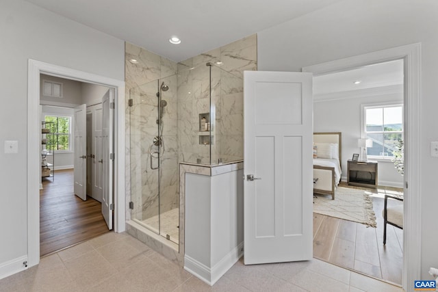 full bath featuring recessed lighting, a marble finish shower, baseboards, and wood finished floors