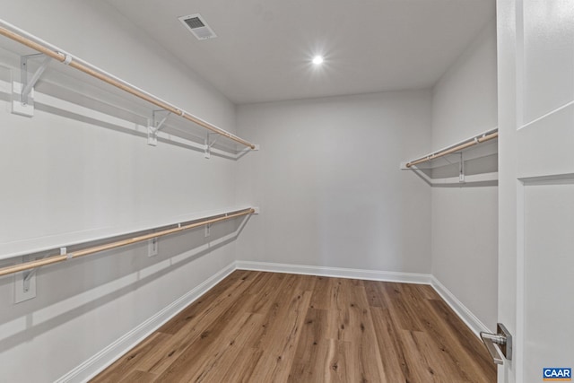 walk in closet with wood finished floors and visible vents