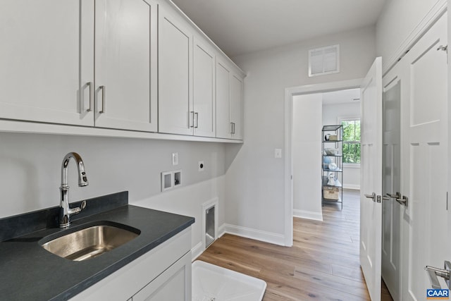 laundry area with electric dryer hookup, visible vents, washer hookup, a sink, and cabinet space