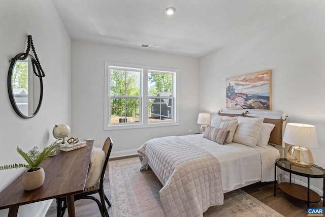 bedroom featuring visible vents, wood finished floors, and baseboards