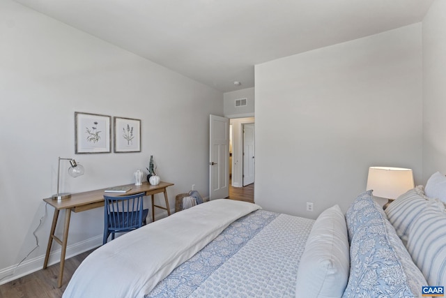 bedroom featuring visible vents, wood finished floors, and baseboards