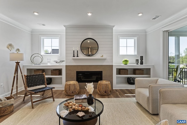 living area with visible vents, a healthy amount of sunlight, and ornamental molding