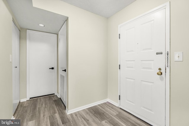 entryway featuring baseboards and wood finished floors