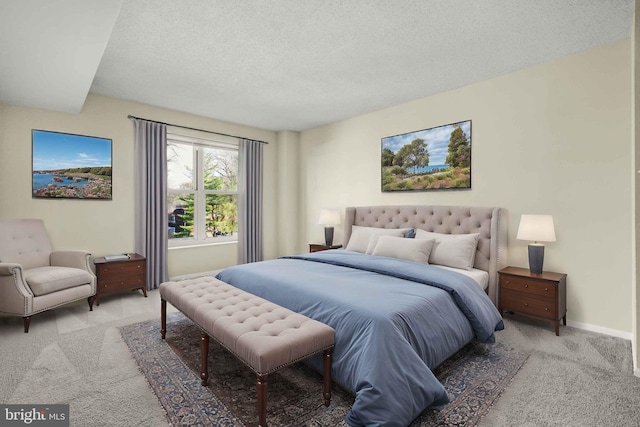 bedroom featuring light colored carpet, baseboards, and a textured ceiling