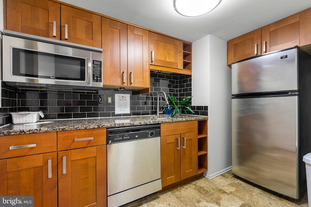 kitchen with open shelves, appliances with stainless steel finishes, brown cabinetry, and a sink