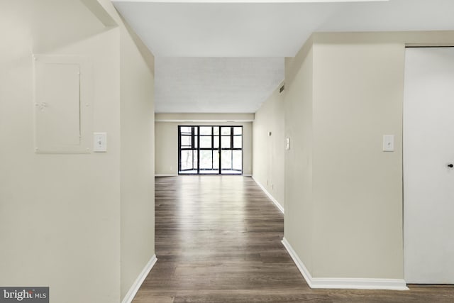 hallway with electric panel, wood finished floors, and baseboards