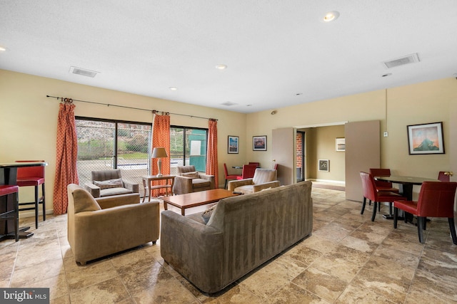 living area with recessed lighting, visible vents, and baseboards