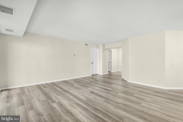 spare room featuring visible vents, baseboards, and light wood-style floors