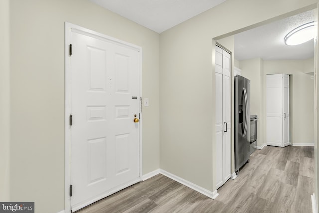 entrance foyer featuring light wood-style floors and baseboards