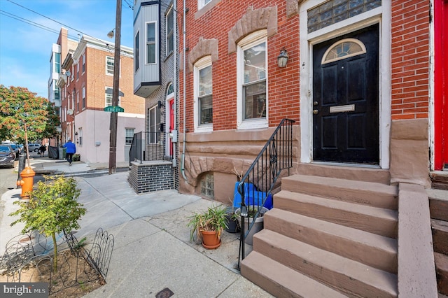 view of exterior entry featuring brick siding