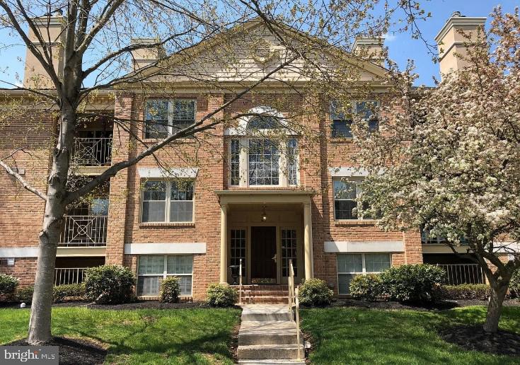 view of front of house featuring a front yard, brick siding, and a chimney