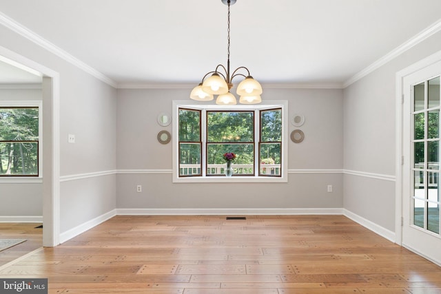 unfurnished dining area featuring baseboards, light wood-style floors, and an inviting chandelier