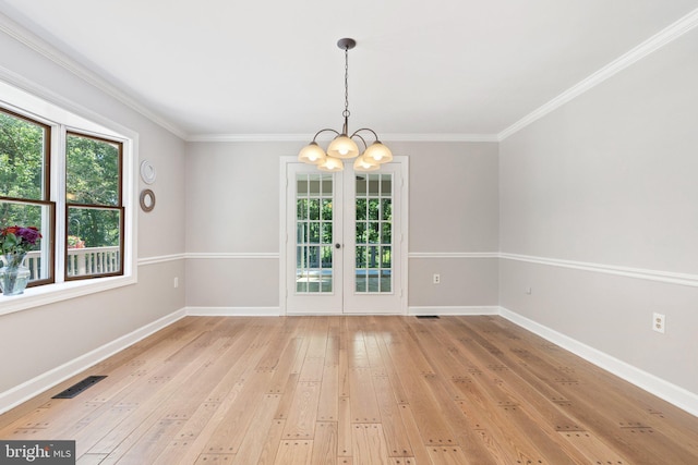 spare room featuring visible vents, baseboards, a notable chandelier, and light wood-style flooring