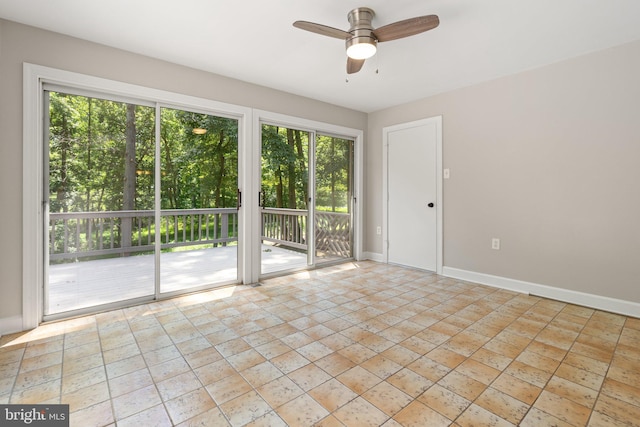 empty room featuring a ceiling fan and baseboards