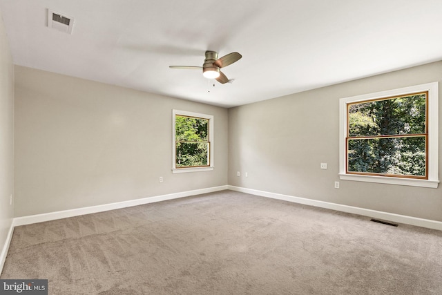 empty room with visible vents, baseboards, ceiling fan, and carpet flooring