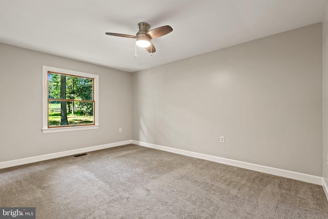 empty room with visible vents, baseboards, a ceiling fan, and carpet flooring