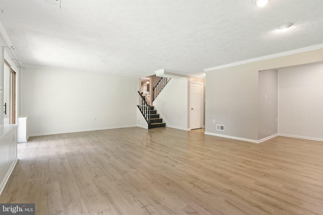 unfurnished living room with stairway, visible vents, a textured ceiling, and light wood-style floors