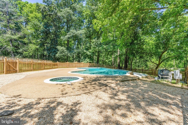 view of pool featuring an in ground hot tub, a fenced in pool, a fenced backyard, and a patio area