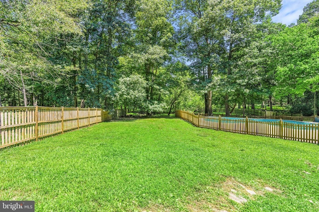 view of yard featuring a fenced in pool and a fenced backyard