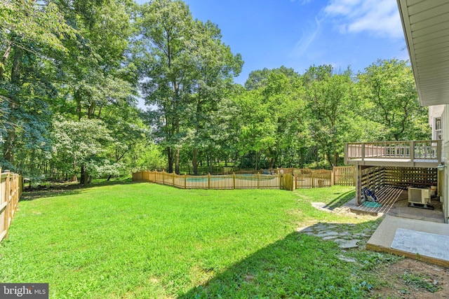 view of yard featuring a deck, central AC, and a fenced backyard