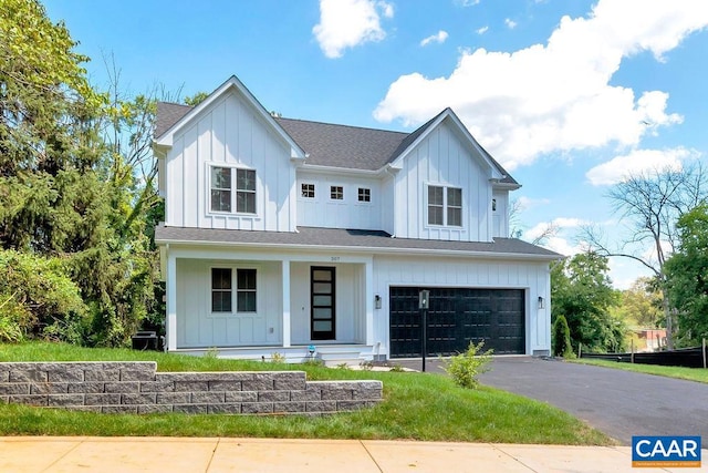 modern farmhouse with driveway, covered porch, board and batten siding, and an attached garage