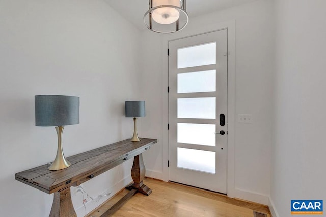 entryway featuring light wood-style flooring, plenty of natural light, and baseboards