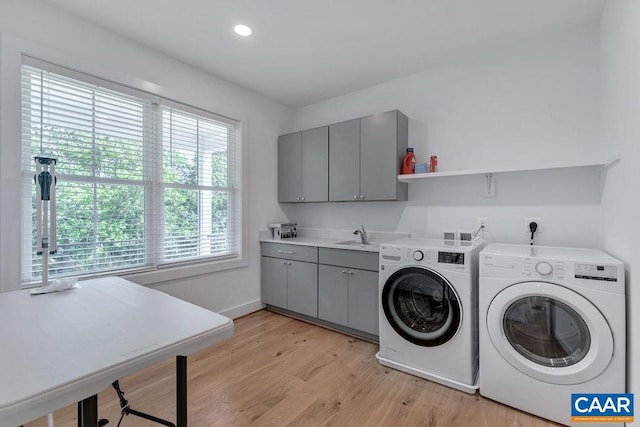 laundry room featuring baseboards, cabinet space, recessed lighting, washing machine and dryer, and light wood-type flooring