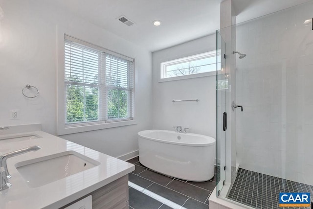 bathroom with a sink, visible vents, a shower stall, and tile patterned flooring