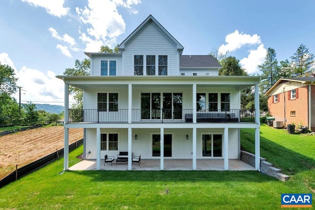 rear view of property with a patio area, central air condition unit, and a lawn