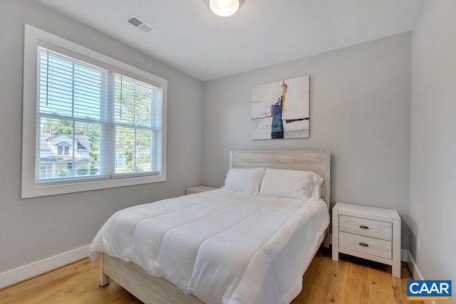 bedroom featuring visible vents, wood finished floors, and baseboards