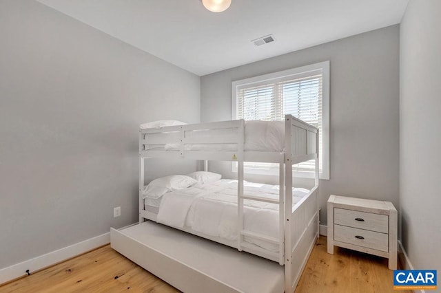 bedroom with visible vents, baseboards, and light wood-style flooring