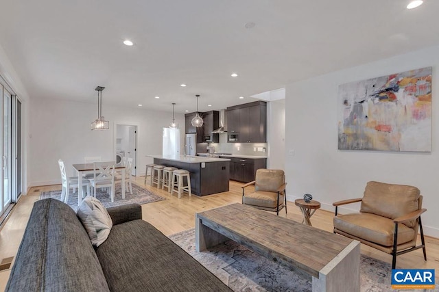 living area with recessed lighting, baseboards, and light wood finished floors