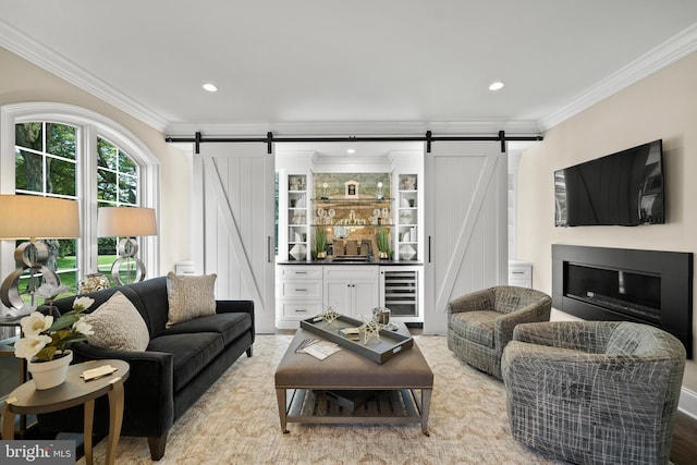 living room featuring a barn door, beverage cooler, and crown molding